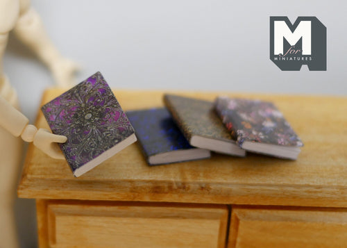 1:12 scale miniature books that open with dark marbled covers, set of 4, shown on a wood dresser