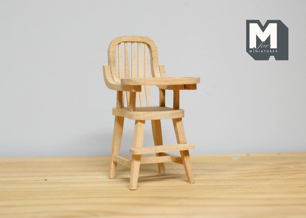 1:12 scale miniature unpainted wood high chair with tray and spindle back, shown on a wood floor against a white wall