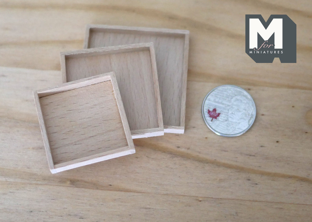 1:12 scale miniature unpainted wood square nesting trays, set of 3, shown on a wood surface beside a coin for scale