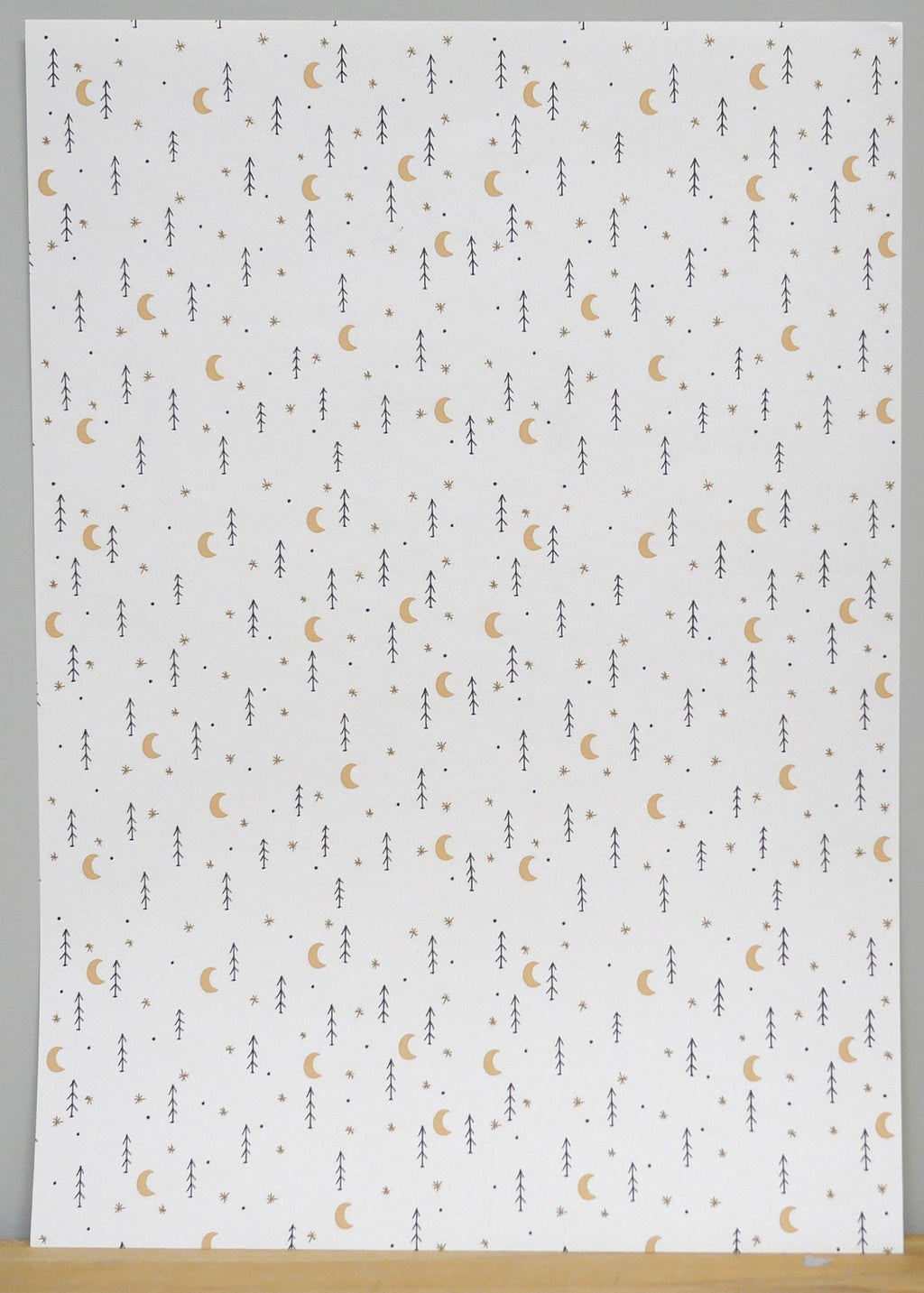 1:12 scale miniature moon and star peel and stick wallpaper in white with small gold moons and dark stars, full sheet
