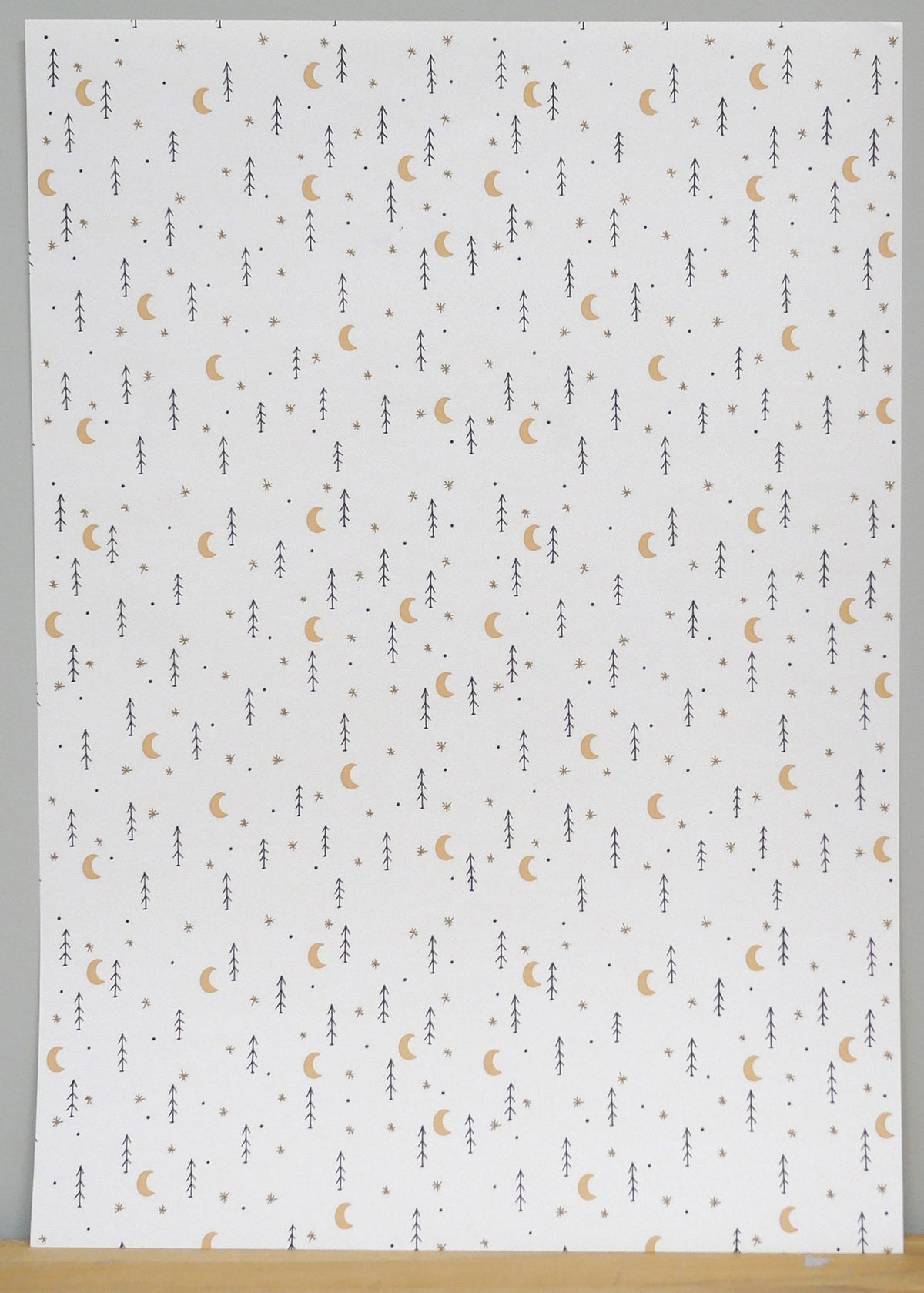 1:12 scale miniature moon and star peel and stick wallpaper in white with small gold moons and dark stars, full sheet