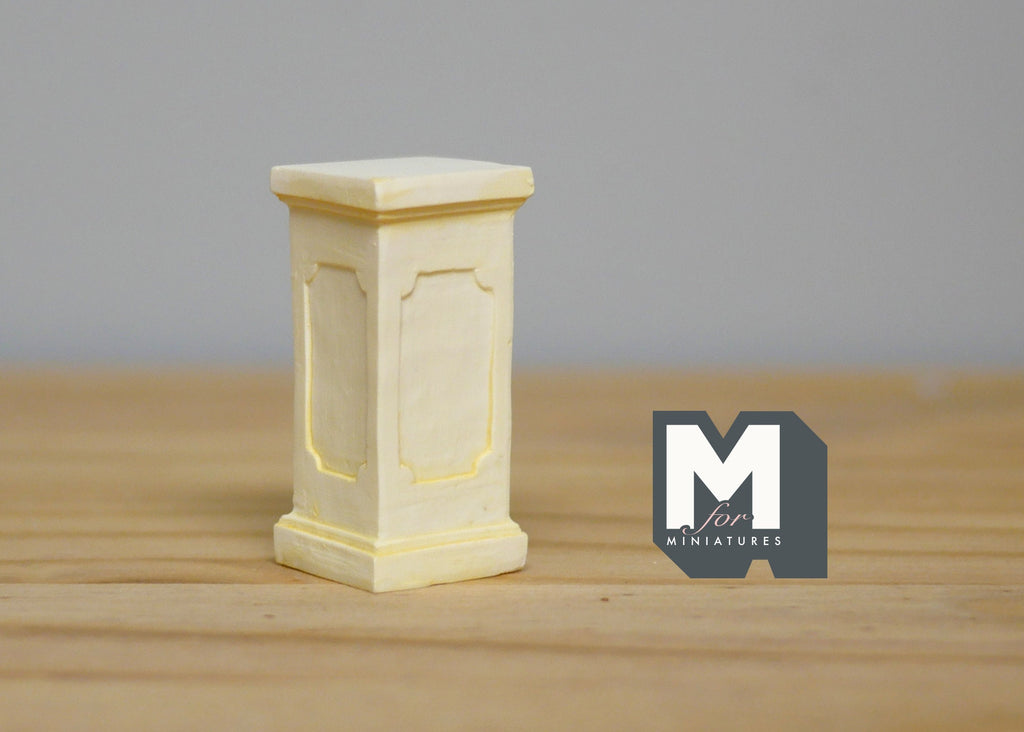 1:12 scale miniature cream square plant pedestal with panel detail, shown on a wood tabletop