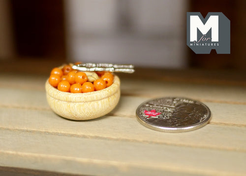 1:12 scale miniature basket of nuts with metal nutcracker, shown on a wood table beside a coin for scale