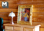 1:12 scale miniature framed flower painting in ornate gold frame, shown on a wood dresser beside a table lamp