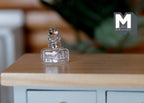 1:12 scale miniature clear glass jar with ribbed lid, square body, shown on a wood countertop