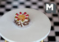 1:12 scale miniature chocolate birthday cake with strawberries and white cream, shown on a round white table