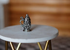 1:12 scale miniature metal beer stein with lid in pewter with embossed detail, shown on a white round table
