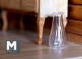 1:12 scale miniature clear glass vase with flared base and ribbed sides, shown on a wood floor by a cabinet