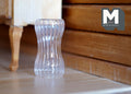 1:12 scale miniature ribbed glass vase with a curved hourglass shape, clear, shown on a white surface by wood furniture