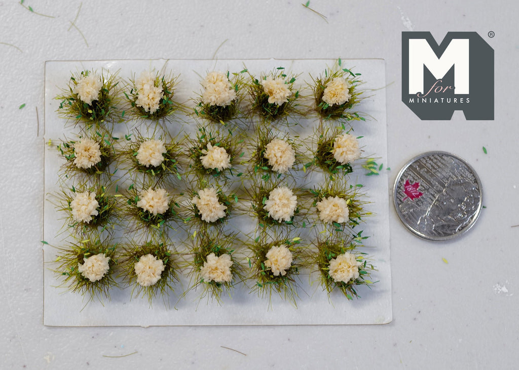 1:12 scale miniature flower cluster tufts in cream with green grass, set of 20, on a sheet beside a coin