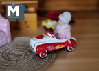 1:12 scale miniature ride on pedal car toy in red and white with flame details, shown with a doll seated inside