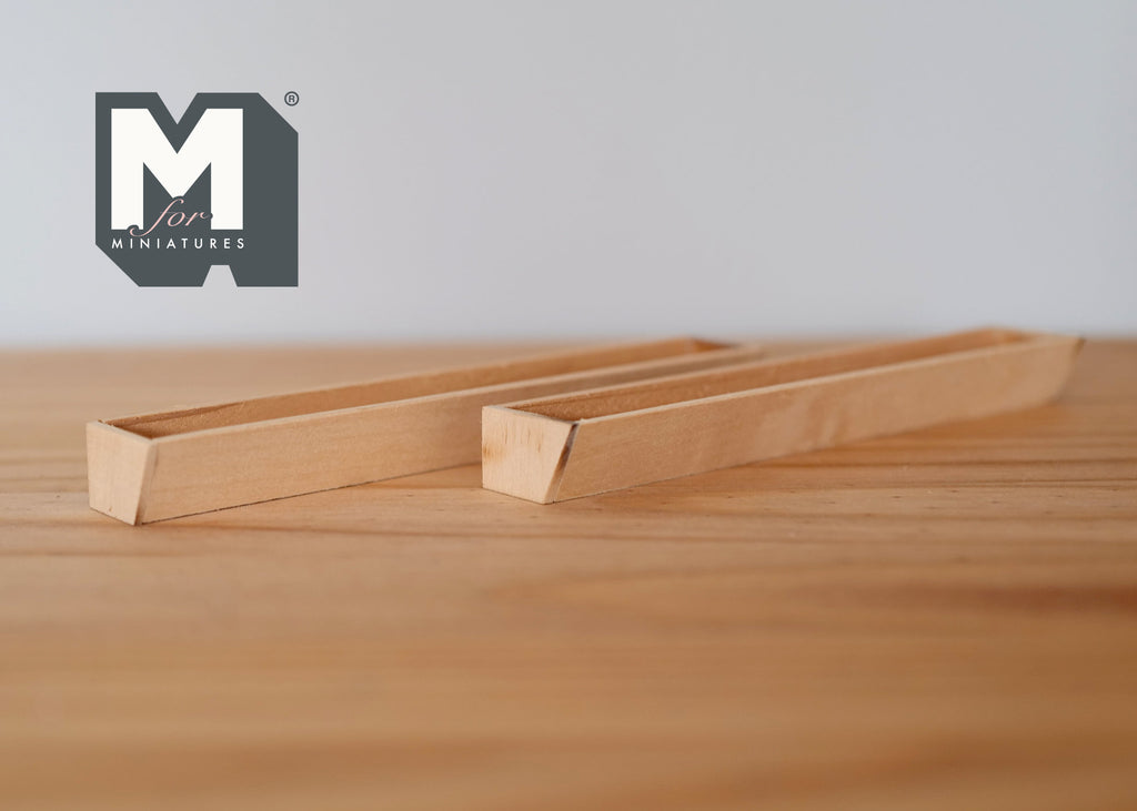 1:12 scale miniature rectangular wood window box planter in natural unfinished wood, shown on a wood table