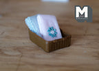 1:12 scale miniature wood bathroom basket with 2 towels, set of 3, blue and white towels in a brown basket on a wood table