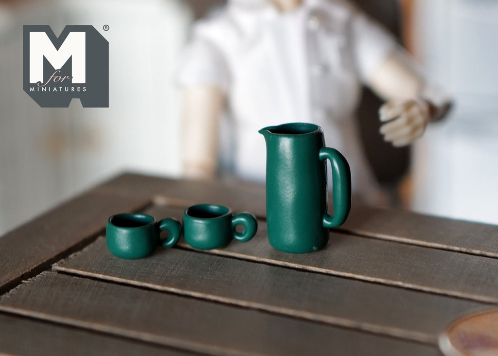 1:12 scale miniature water pot, kettle, cups and mug set in dark green, 5 pieces, shown on a dark wood table