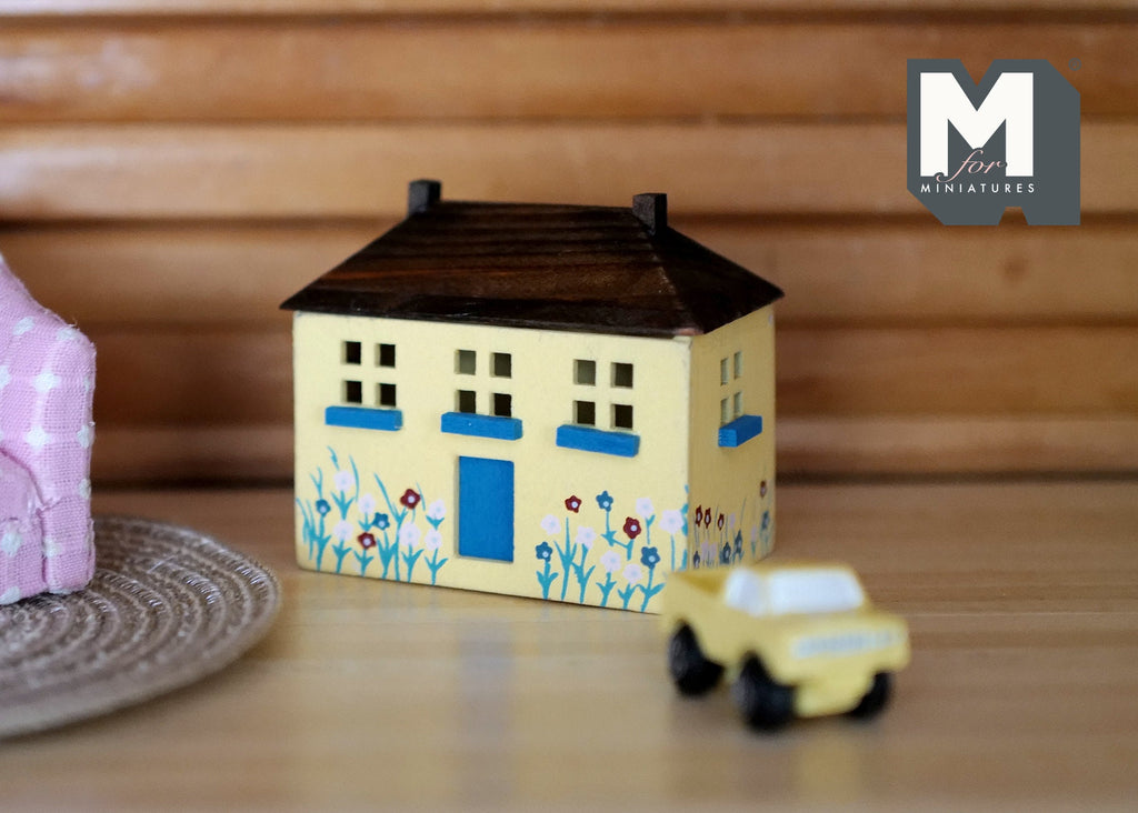 1:12 scale miniature wood house shaped toy box in cream with opening roof lid, painted flowers, shown beside a toy car