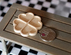1:12 scale miniature wood flower shaped tray in bare wood with four heart shaped sections, shown beside a coin