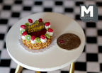 1:12 scale miniature kiwi strawberry birthday cake with nut sides and chocolate plaque, shown beside a coin