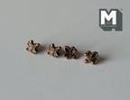1:12 scale miniature antique bronze fleur de lis cabinet knobs, set of 4, shown in a row on a gray surface