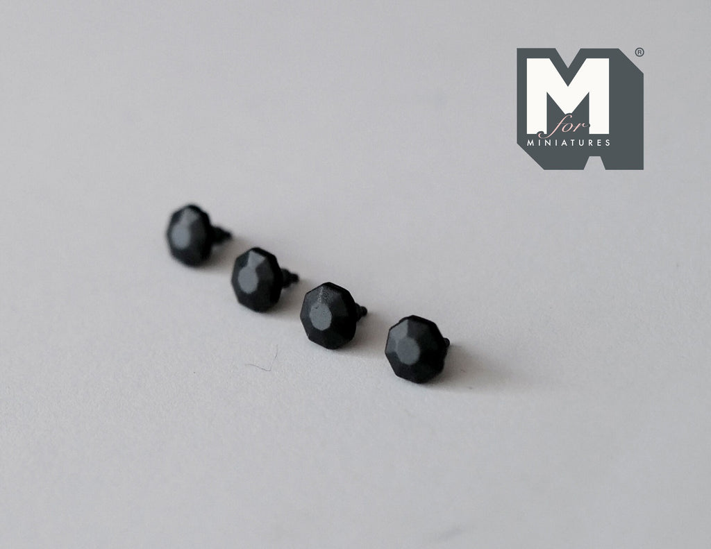 1:12 scale miniature matte black faceted cabinet knobs, set of 4, shown in a row on a gray surface