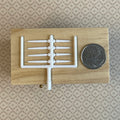 1:12 scale miniature white taper candles, pack of 8 with 4 long and 4 short on a sprue, shown beside a coin for scale