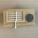 1:12 scale miniature white taper candles, pack of 8 with 4 long and 4 short on a sprue, shown beside a coin for scale