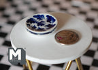 1:12 scale miniature ceramic round plates with blue floral pattern, set of 2, blue and white, shown beside a coin