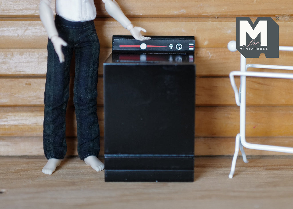 1:12 scale miniature wood top load washing machine in black with opening lid and control panel, beside a figure