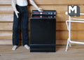 1:12 scale miniature wood top load washing machine in black with opening lid and control panel, beside a figure