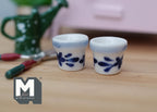 1:12 scale miniature ceramic round flower pots with blue and white floral pattern, set of 2, shown with garden tools