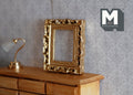 1:12 scale miniature deep carved ornate rectangular picture frame in gold, shown empty on a wood dresser by a lamp