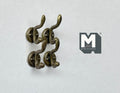 1:12 scale miniature antique bronze wall hooks with double curved prongs, set of 4, on a white surface