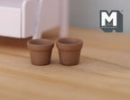 1:12 scale miniature clay flower pots with rim, set of 2, unglazed terracotta, shown empty on a wood floor
