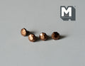 1:12 scale miniature antique bronze faceted cabinet knobs, set of 4, shown in a row on a gray surface