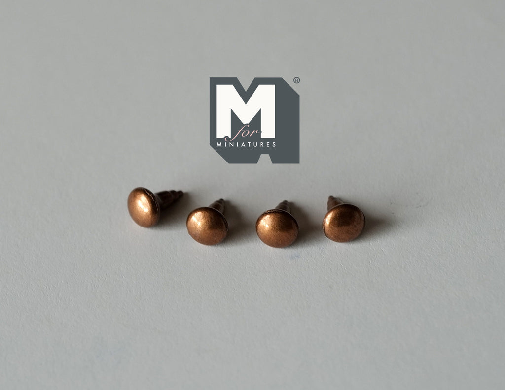 1:12 scale miniature copper domed cabinet knobs with pin backs, set of 4, shown in a row on a gray surface
