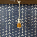 1:12 scale miniature chain drop pendant light with amber glass shade, 12V with plug, hanging against navy anchor wallpaper