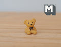 1:12 scale miniature tan teddy bear with brown bow tie, sitting, shown on a wood tabletop