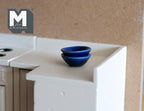 1:12 scale miniature small ceramic bowls in cobalt blue, set of 2, shown stacked on a white kitchen counter