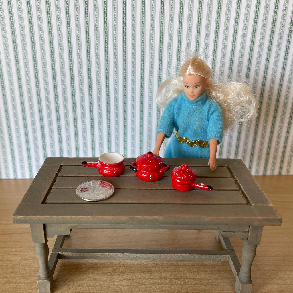 1:12 scale miniature red wood cooking pots with floral decoration, set of 3, shown on a kitchen table beside a doll