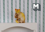 1:12 scale miniature ginger tabby cat, sitting and grooming with raised paw, shown against green striped wallpaper