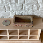 1:12 scale miniature garden trough in stone look cast resin, rectangular, on a wood shelf beside a coin for scale