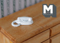 1:12 scale miniature push button telephone in white with a coiled cord, shown on a wood dresser