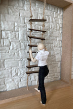 1:12 scale miniature rope ladder with dark wood rungs, shown hanging on a white stone wall with a figure climbing