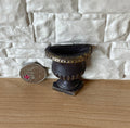 1:12 scale miniature half round wall planter in black, flat back urn shape with gold trim, shown beside a coin