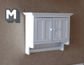 1:12 scale miniature white wood kitchen wall cabinet with 2 panel doors and bottom shelf, shown mounted on a wall