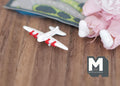 1:12 scale miniature toy biplane in white with red trim, shown on a wood floor beside a plush toy