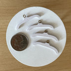 1:12 scale miniature wood clothes hangers in white with silver hooks, set of 4, shown on a white plate beside a coin