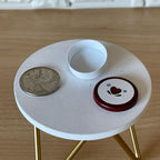1:12 scale miniature red and white metal round tin with heart lid, shown open on a white table beside a coin