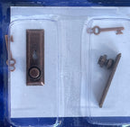 1:12 scale miniature door knobs with keyhole plates and keys in bronze, set of 2, shown in clear blister packaging