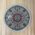 1:12 scale miniature round area rug in gray and red with center medallion and border, shown on a wood floor with a coin