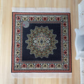1:12 scale miniature navy square area rug with center medallion, floral border and cream fringe, on a wood floor with a coin